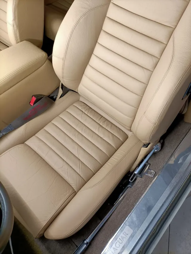 Revnet sæde i beige læder i en Jaguar efter renovering